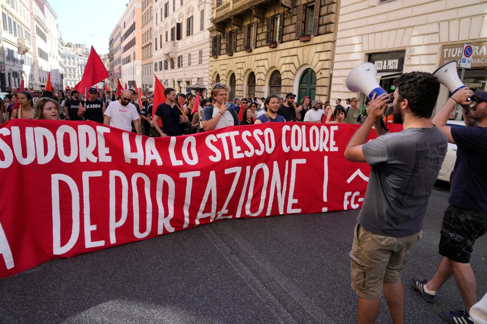 People hold a banner in Italian reading