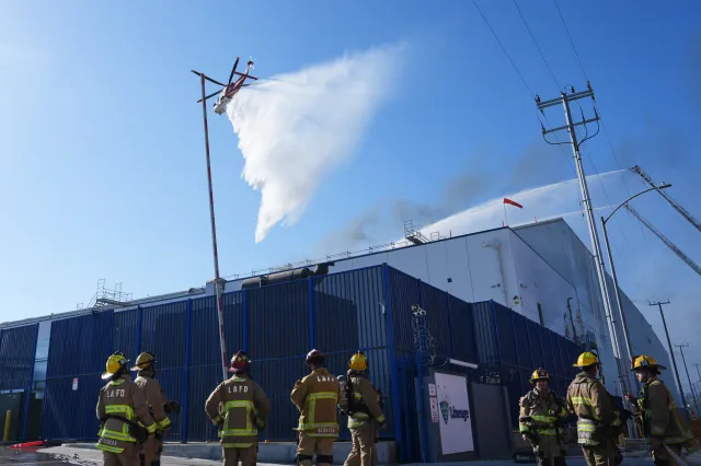 Water is dropped by helicopter at a warehouse fire in the Boyle Heights section of Los Angeles on Wednesday, June 17, 2026.