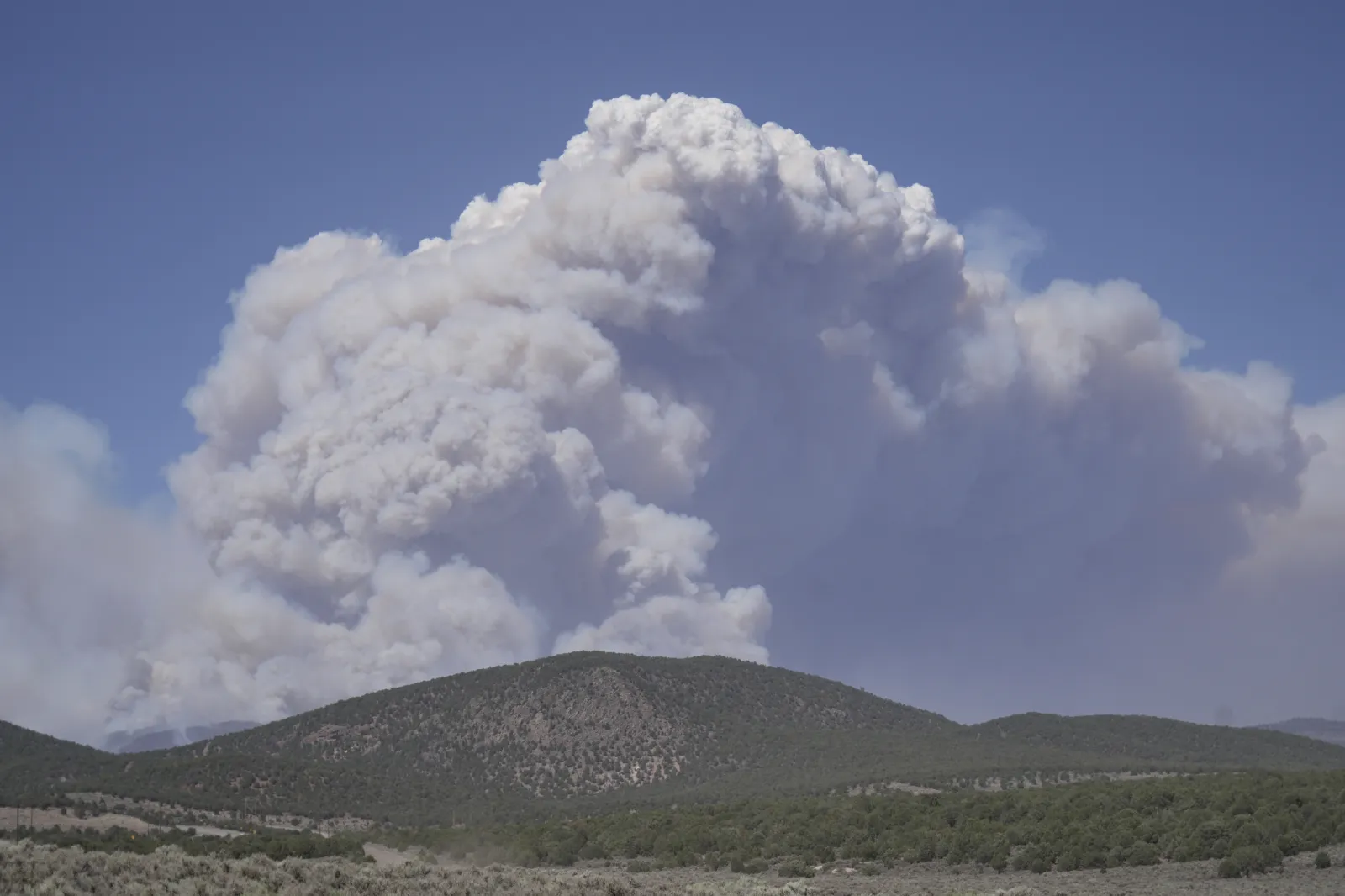 A plume of smoke rises from the Cottonwood Fire on June 26 near Beaver, Utah. (AP Photo/Ty ONeil)