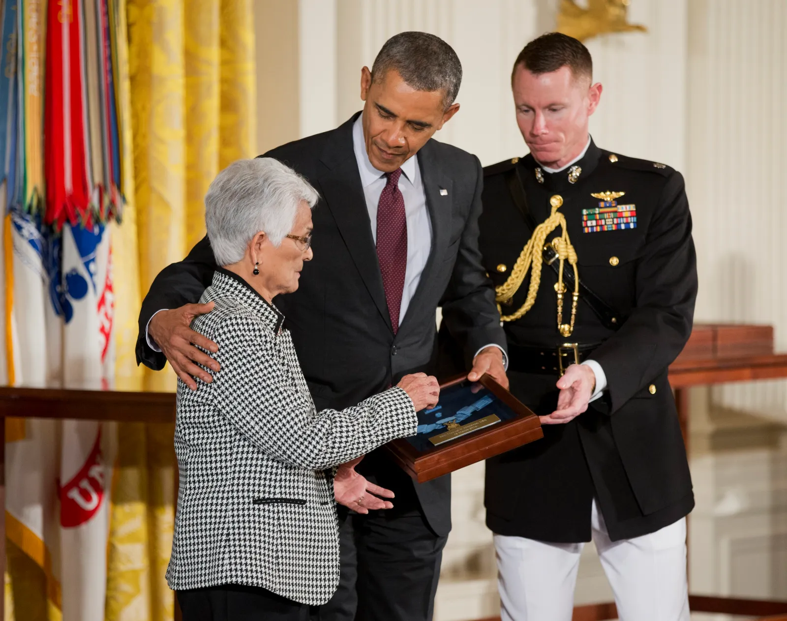 CORRECTS TO ALICE MENDOZA - Alice Mendoza, left, accepts the Medal of Honor on behalf of her husband, Staff Sgt. Manuel V. Mendoza, from President Barack Obama, during a ceremony in the East Room of the White House on Tuesday, March 18, 2014, in Washington. President Obama awarded the Medal of Honor to 24 ethnic or minority U.S. soldiers who performed acts of bravery under fire in three of the nations wars, that were denied because of prejudice.