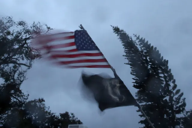Flags blow in the winds of Hurricane Matthew, October 7, 2016 on Cocoa Beach, Florida | Getty Images