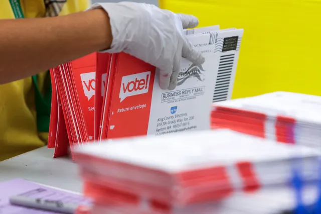 An election worker opens envelopes containing vote-by-mail ballots for the August 4 Washington state primary at King County Elections in Renton, Washington on August 3, 2020.