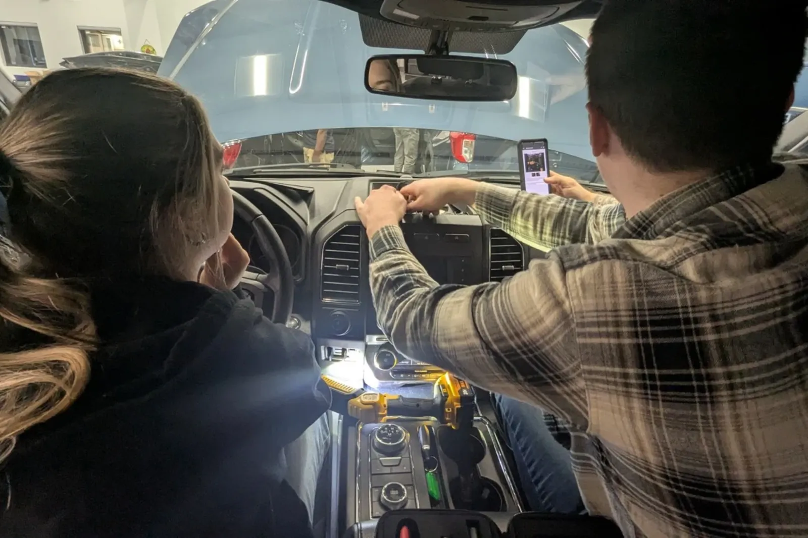 Students physically remove a vehicle's main computer to extract potential evidence from the device.