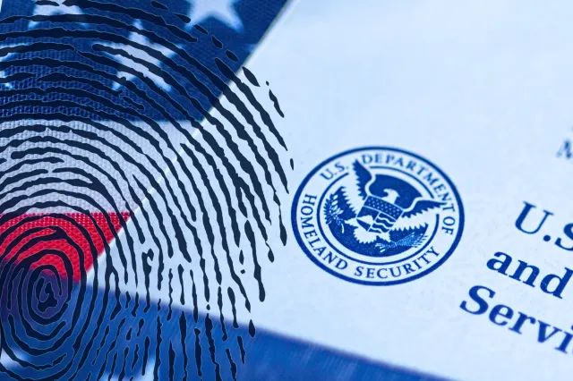 Newsweek graphic: Zoomed in letter from USCIS covered in flag of USA from taken in Washington, DC, USA, September, 16, 2019 and fingerprint illustration.