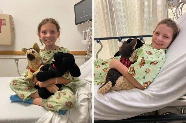 Emmy sitting in a hospital bed with her stuffed animals.