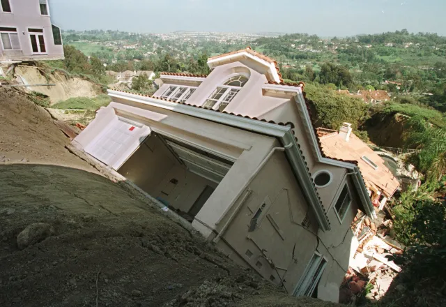 File picture: A luxury home in the Orange County suburb of Laguna Niguel slips down a hillside on 19 March, 1998, eroded by heavy El Nino generated rains earlier in the month. (Photo by VINCE BUCCI/AFP via Getty Images)