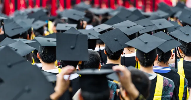 Stock image of new college graduates in caps and gowns.