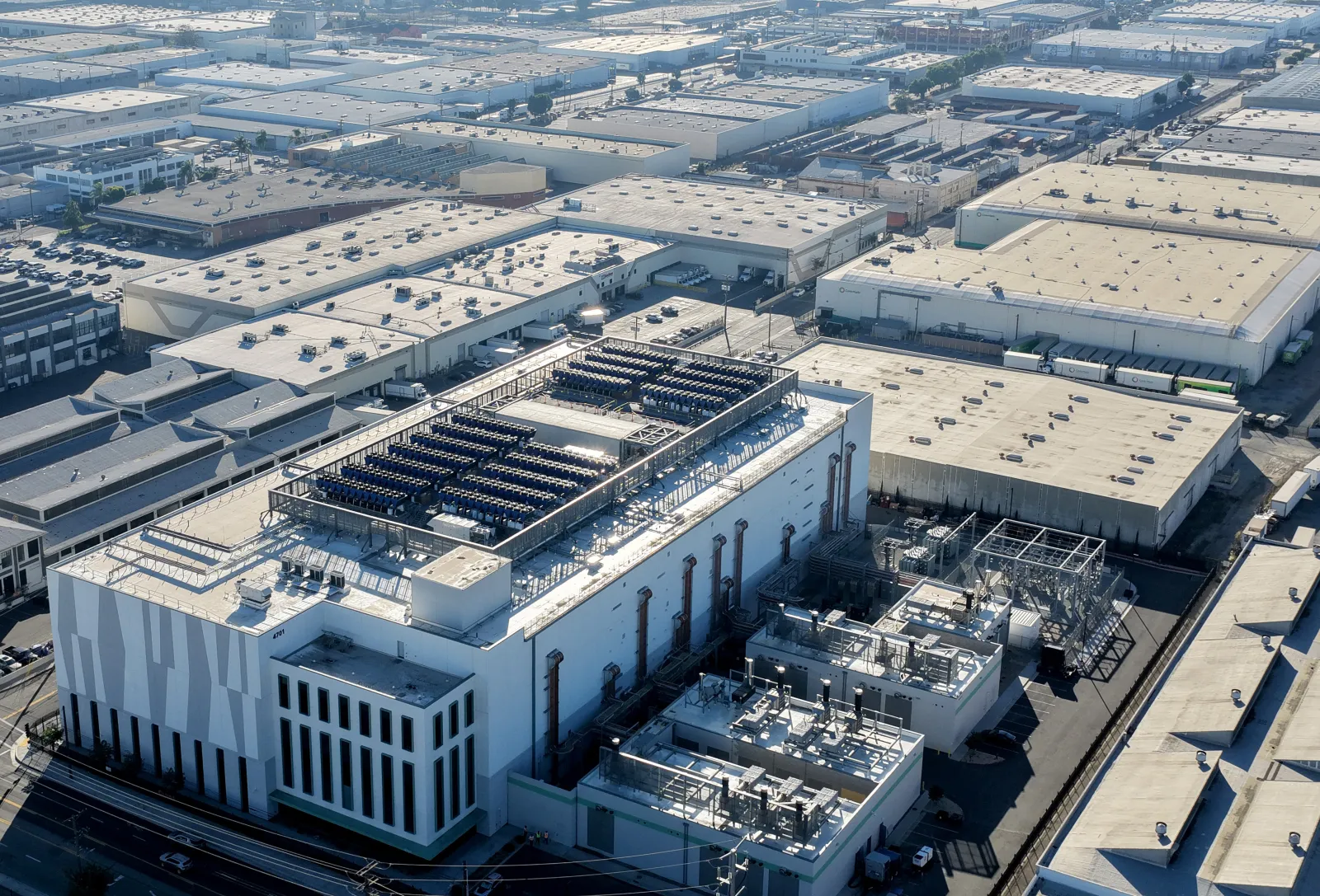 Aerial view of a 33 megawatt data center with a closed-loop cooling system, amid warehouses in Vernon, California.