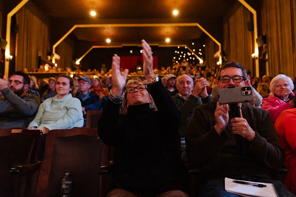 Leslie Harlow, mother of U.S. Senate candidate Graham Platner of Maine, applauds her son during a town hall at the Leavitt Theater on October 22, 2025, in Ogunquit, Maine. Platner, an oyster farmer and Marine veteran, is running to unseat Republican Susan Collins.