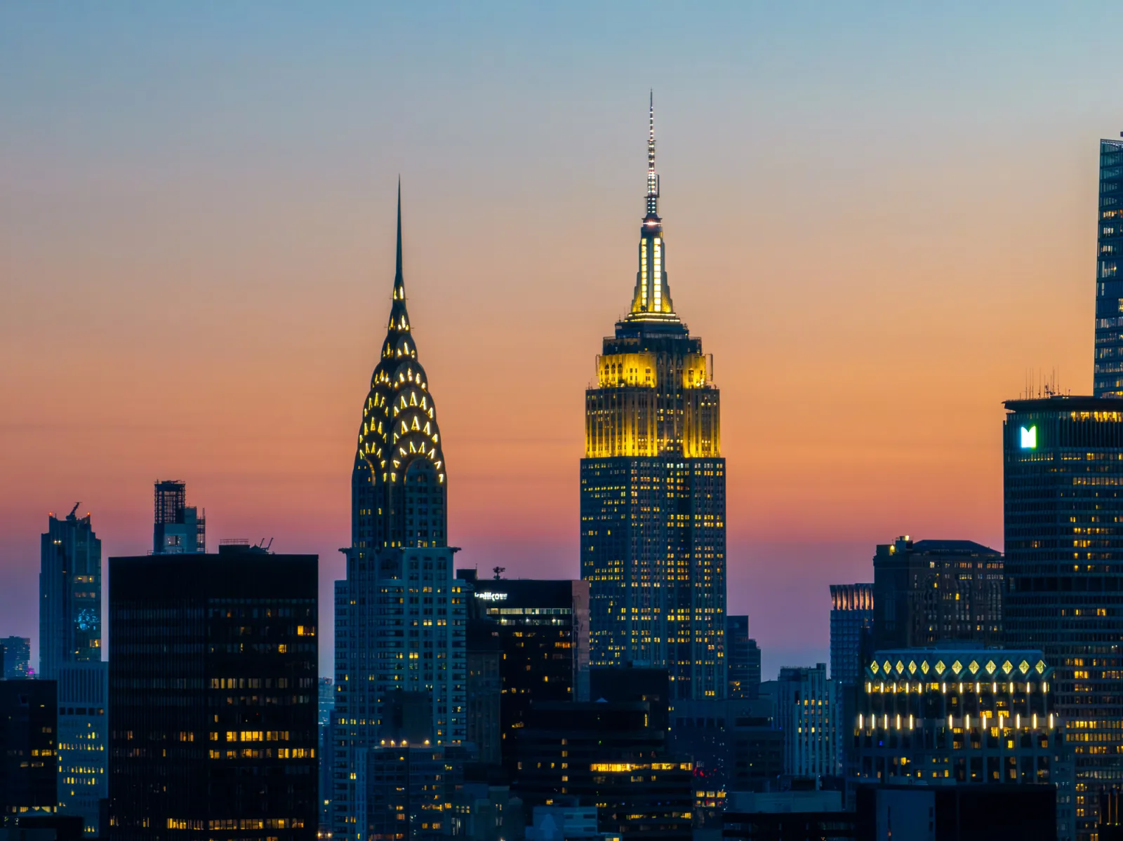 The Chrysler Building (left) and Empire State Building illuminated at sunset in Manhattan.