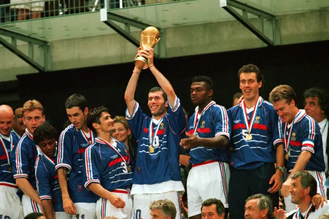 Zinedine Zidane celebrates soccer World Cup victory, lifting the trophy after France beat Brazil 3-0 at the Stade de France on July 12, 1998, in Paris (Photo by Soccrates Images/Getty Images)
