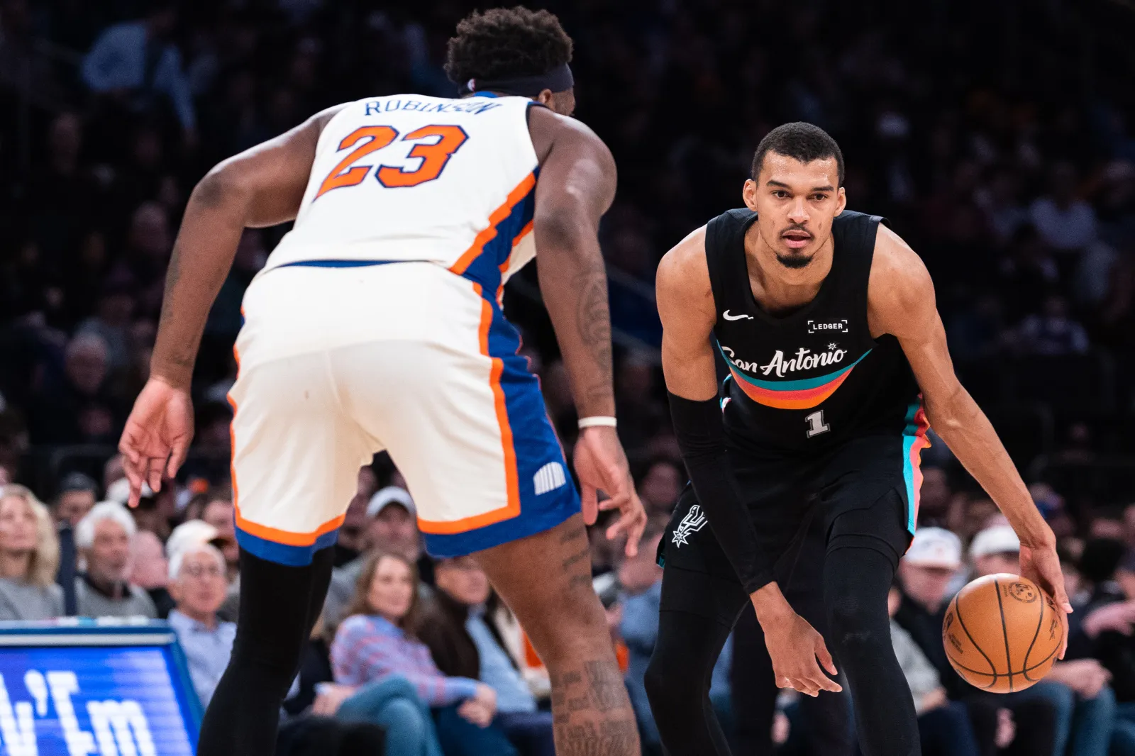 Victor Wembanyama of San Antonio Spurs guarded by New York Knicks center Mitchell Robinson