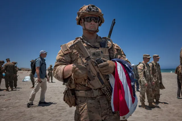 A soldier holds onto a U.S flag during a counter-landing live fire exercise as part of the annual Balikatan joint military drills on May 4, 2026 in Laoag, Ilocos Norte province, in the Philippines.