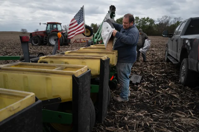 Alan Montag, a third-generation Iowa farmer, and his son Aden load soybean seed into a planter on May 6 near West Bend, Iowa. (Photo by Scott Olson/Getty Images)