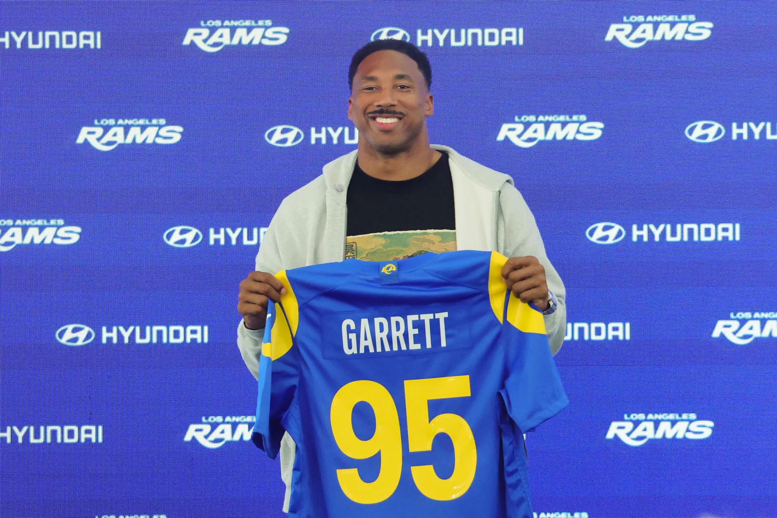 WOODLAND HILLS, CALIFORNIA - JUNE 2: Myles Garrett #95 of the Los Angeles Rams poses with his jersey during a press conference after an organized team activities workout at Rams Village at the Warner Center on June 2, 2026 in Woodland Hills, California.  (Photo by Kevin Terrell/Getty Images)