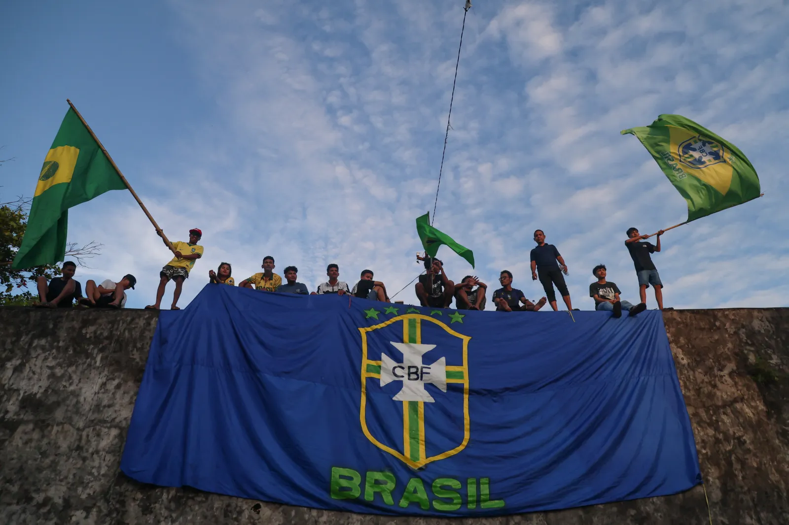 Football fans wave Brazilian flags as they watch the FIFA World Cup 2026 Group C match between Brazil and Morocco on a giant screen during a public viewing event at Fort Oranje in Ternate, North Maluku, on June 14, 2026. (Photo by AZZAM RIZQULLAH / AFP via Getty Images)