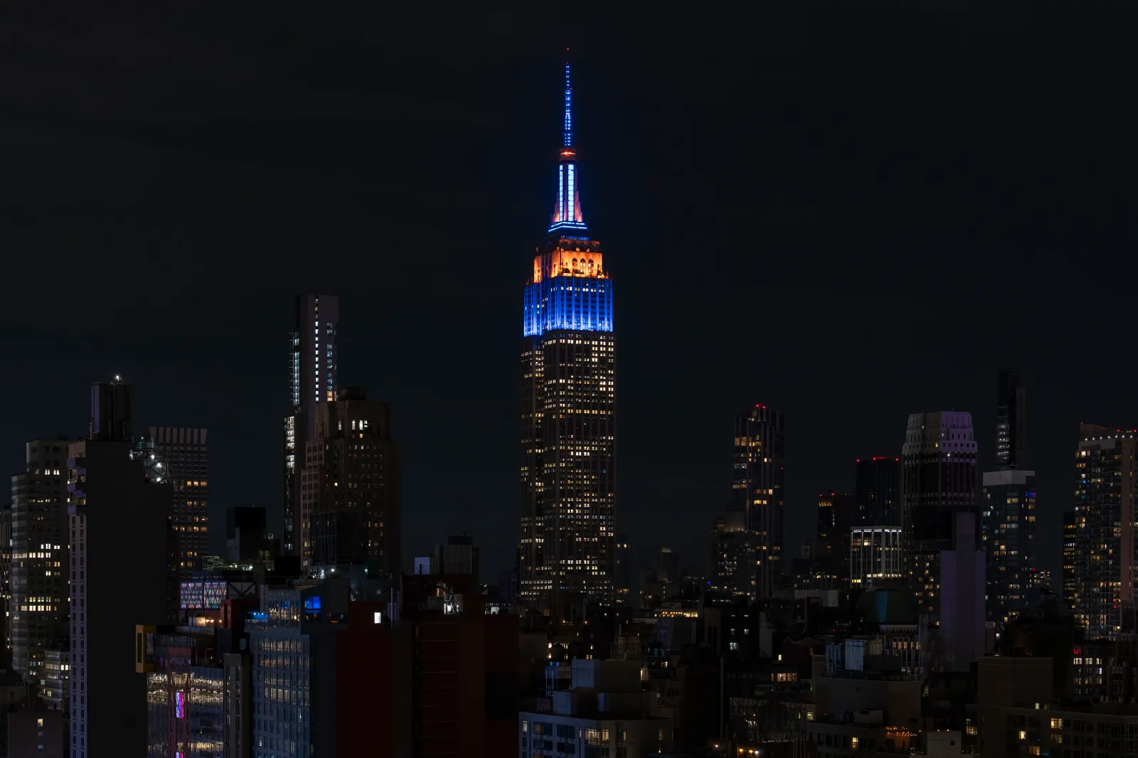 The Empire State Building is lit up in blue and orange in honor of the New York Knicks game 4 win of the NBA playoffs against the San Antonio Spurs in New York on June 11, 2026, in New York City.