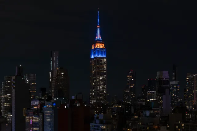 The Empire State Building is lit up in blue and orange in honor of the New York Knicks game 4 win of the NBA playoffs against the San Antonio Spurs in New York on June 11, 2026, in New York City.