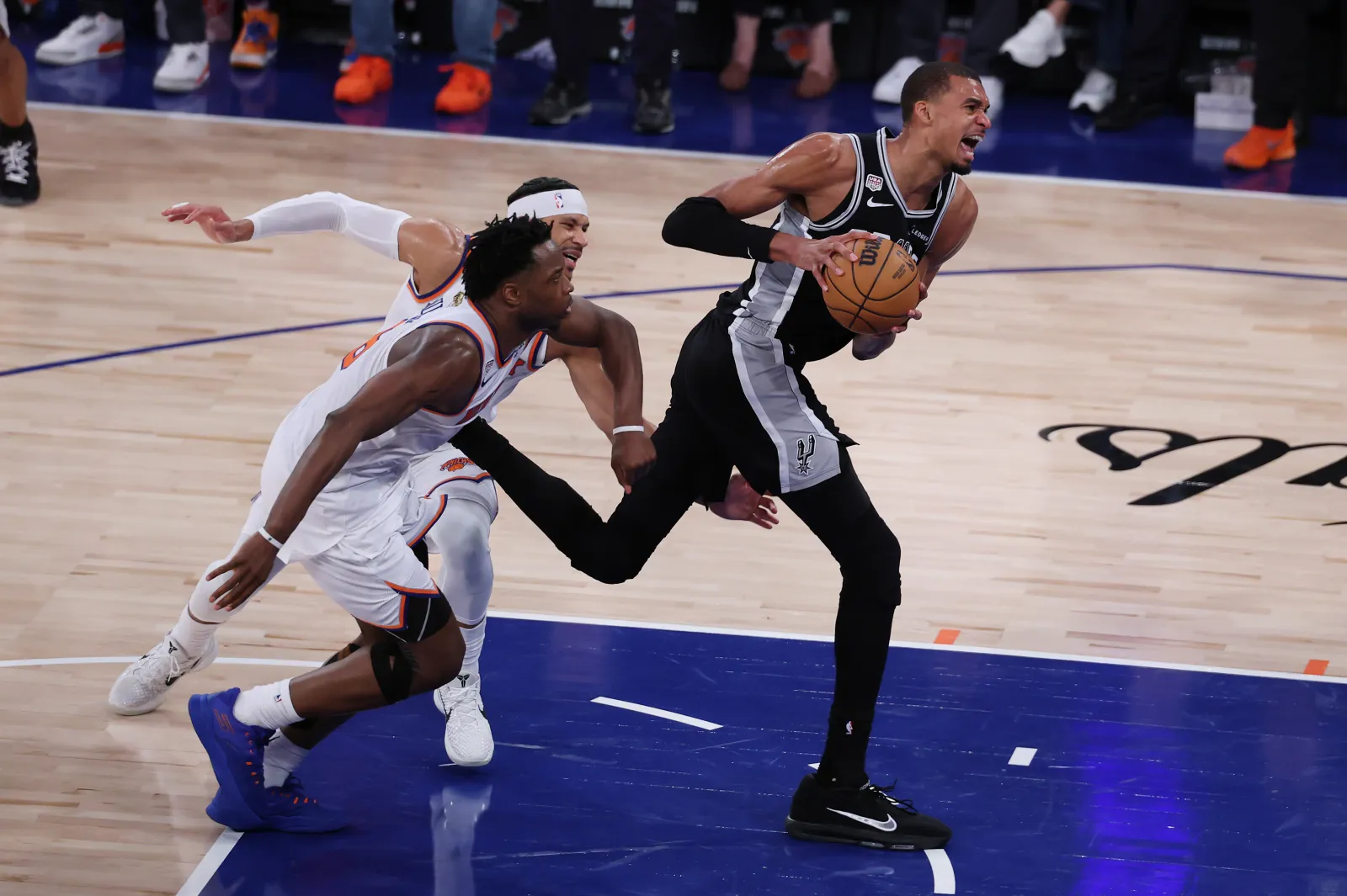 NEW YORK, NEW YORK - JUNE 10: Victor Wembanyama #1 of the San Antonio Spurs is fouled by Josh Hart #3, and Og Anunoby #8 of the New York Knicks during the fourth quarter in Game Four of the 2026 NBA Finals at Madison Square Garden on June 10, 2026 in New York City. (Photo by Al Bello/Getty Images)
