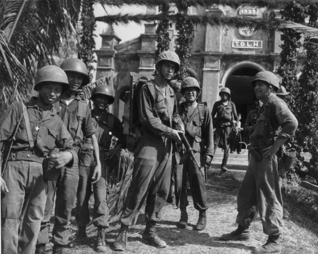 US Marines and soldiers of the Army of the Republic of Vietnam stand and pose with their weapons during a break from a patrol near Da Nang during the Vietnam War, in April 1965.