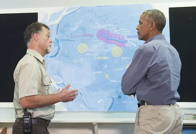 US President Barack Obama, alongside refuge manager Bob Peyton, looks at a map of Midway Atoll in the Papahanaumokuakea Marine National Monument in the Pacific Ocean, September 1, 2016. (SAUL LOEB/AFP via Getty Images)