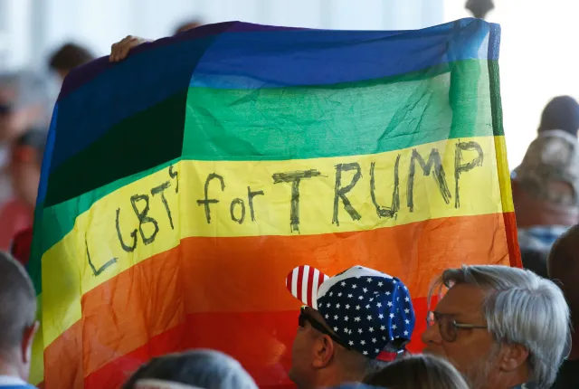 Supporters hold up a rainbow