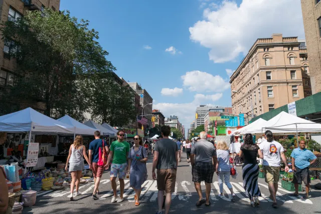 People walks down 2nd Avenue in the East Village district of New York City.