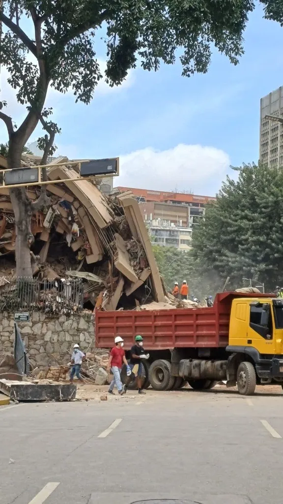 Caracas'ta depremlerin ardından kurtarma çalışmaları devam ederken, işçiler yıkılan bir binanın enkazında arama yapıyor.