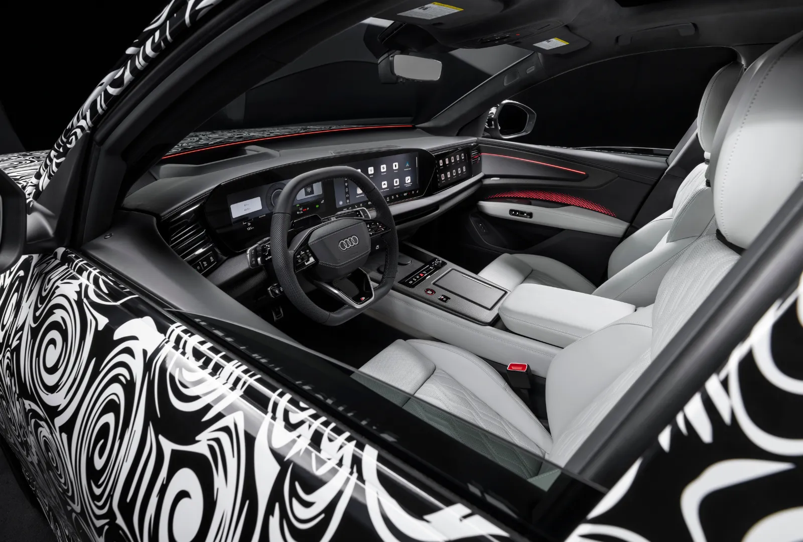 Interior of Audi Q9 through the window showing a camouflaged exterior.