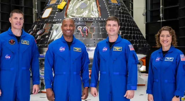 The Artemis II crew—from left: Jeremy Hansen, mission specialist; Victor Glover, pilot; Reid Wiseman, commander; and Christina Hammock Koch, mission specialist—inside the Neil Armstrong Operations and Checkout Building at NASA’s Kennedy Space Center in Florida in front of their Orion crew module on August 8, 2023. (NASA/Kim Shiflett)