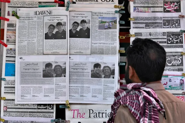 A man looks at morning newspapers as some papers published an ad of condolence massages for two victims of Titan submersible incident, Shahzada Dawood and his son Suleman Dawood, by their family and firm, at a roadside stall, in Islamabad, Pakistan, Tuesday, June 27, 2023.