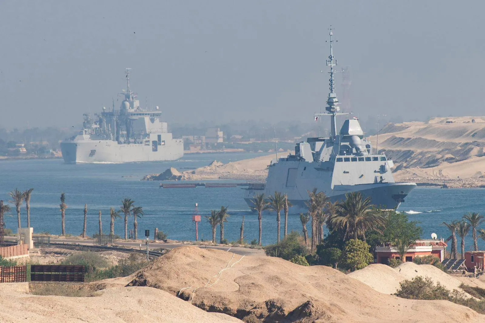 Vessels attached to the French Navy's Charles de Gaulle Carrier Strike Group transit the Suez Canal en route to the southern Red Sea to pre‑position for a possible mission to restore navigation in the Strait of Hormuz, on May 6.