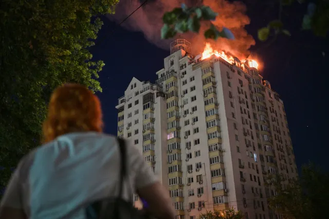 A woman looks at an apartment building burning after a Russian missile attack in Kyiv, Ukraine, on July 2, 2026.