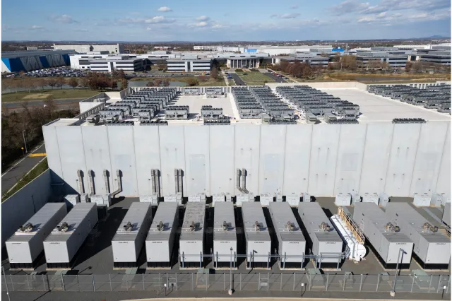 Cooling vent fans are seen on the roof next to generators at a Digital Realty data center in Ashburn, Virginia, on November 12, 2025.