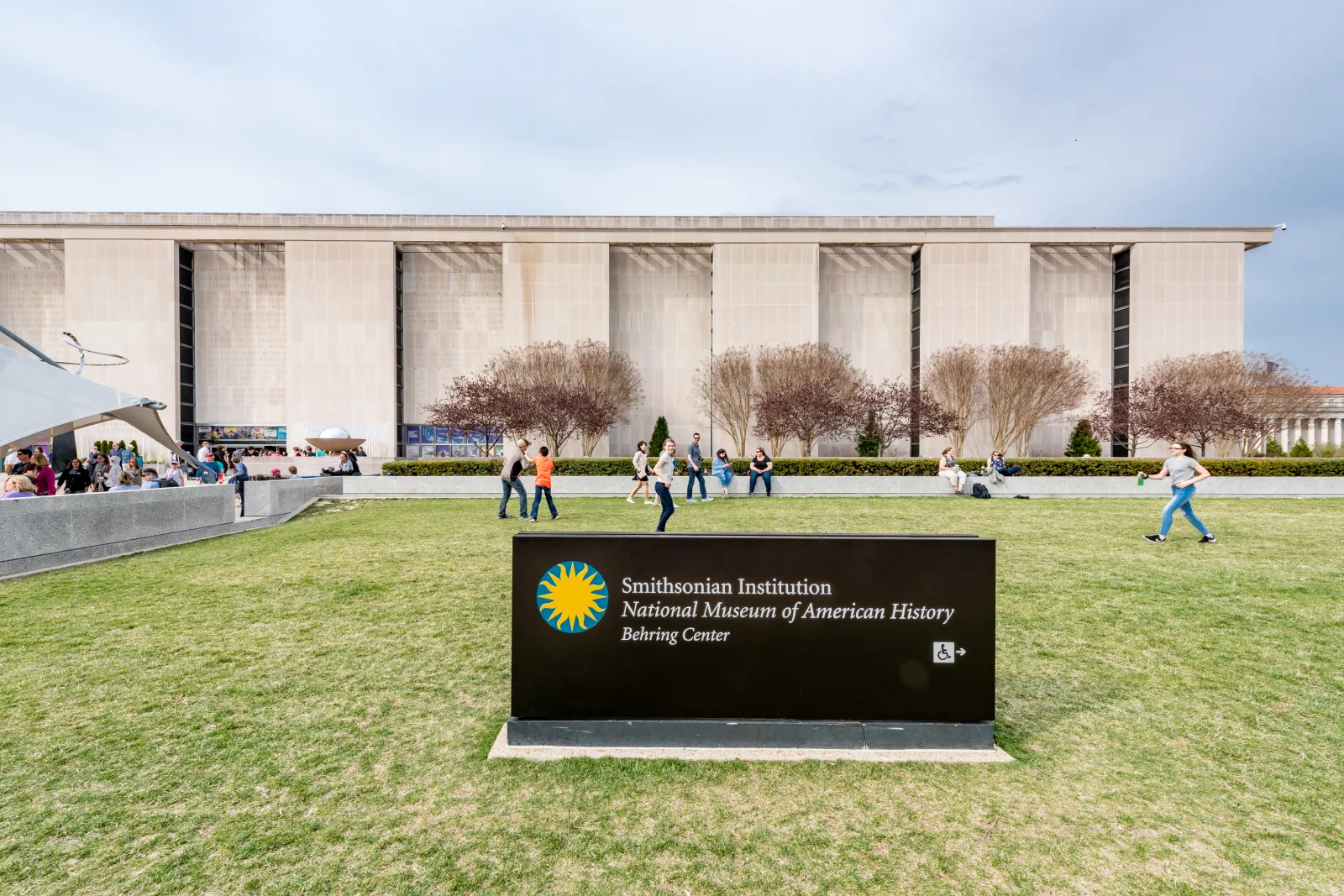 Tourists at the facade of the National Museum of American History museum of the Smitshonian Institute in Washington DC, USA.