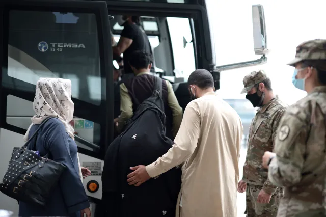 Refugees board a bus at Dulles International Airport that will take them to a refugee processing center after being evacuated from Kabul following the Taliban takeover of Afghanistan on August 31, 2021 in Dulles, Virginia.