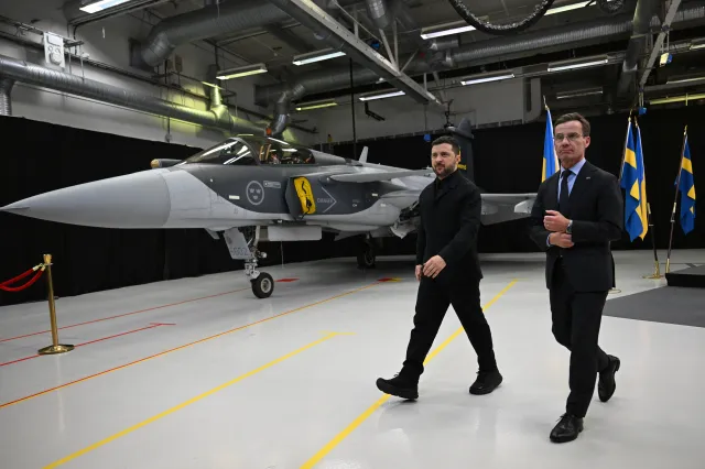 Swedish Prime Minister Ulf Kristersson, right, and Ukrainian President Volodymyr Zelensky walk past a Gripen fighter jet after they delivered a joint press conference in Linkoping, Sweden, on October 22, 2025.