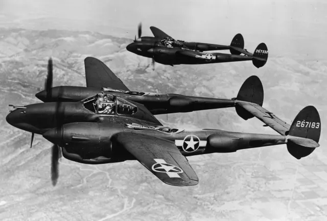 Two Lockheed P-38 Lightning aircraft fly during World War II's Pacific campaign circa 1943.