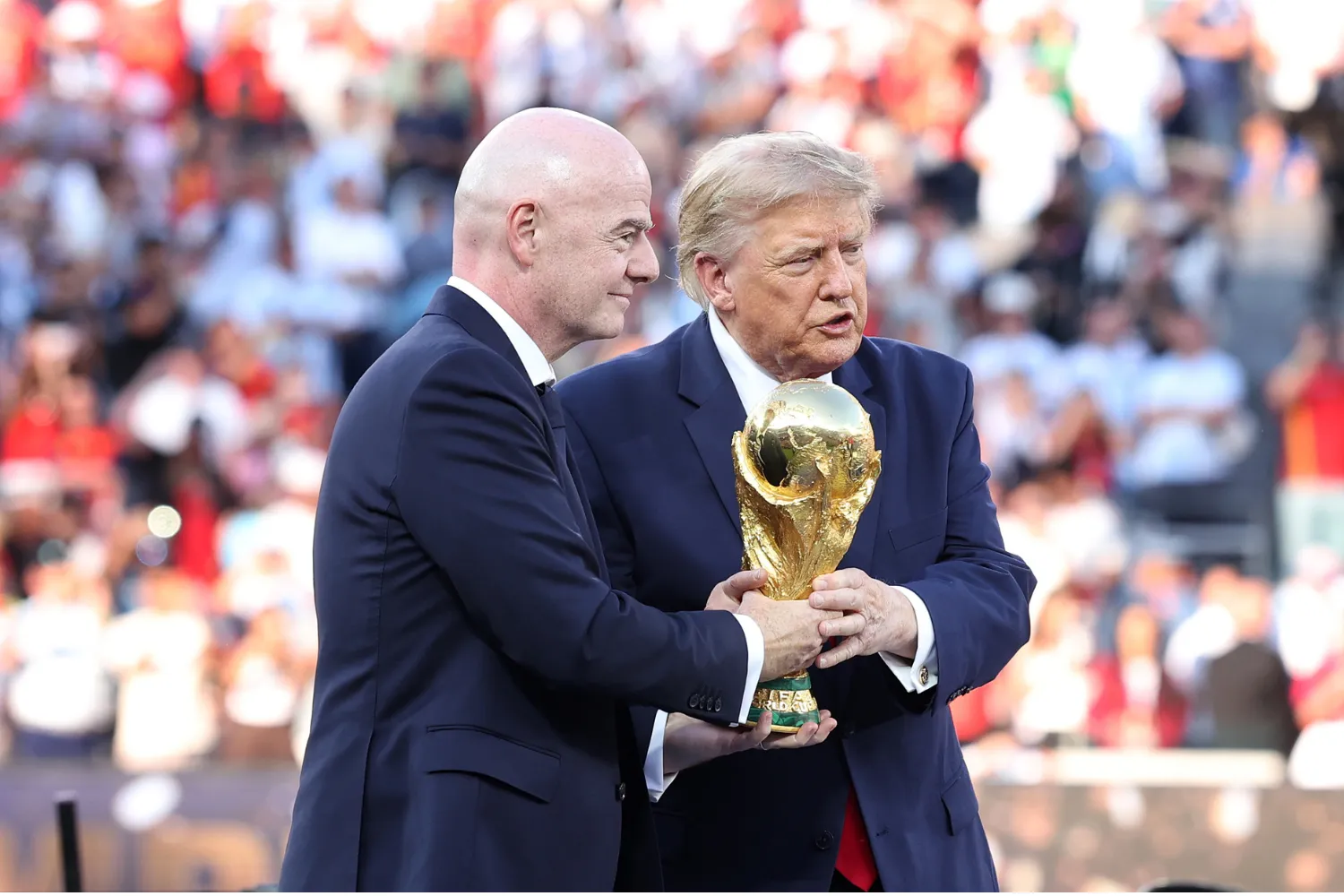 Donald Trump, president of the United States of America, and Gianni Infantino, president of FIFA, carry the FIFA World Cup trophy at New York New Jersey Stadium on July 19, 2026 in East Rutherford.