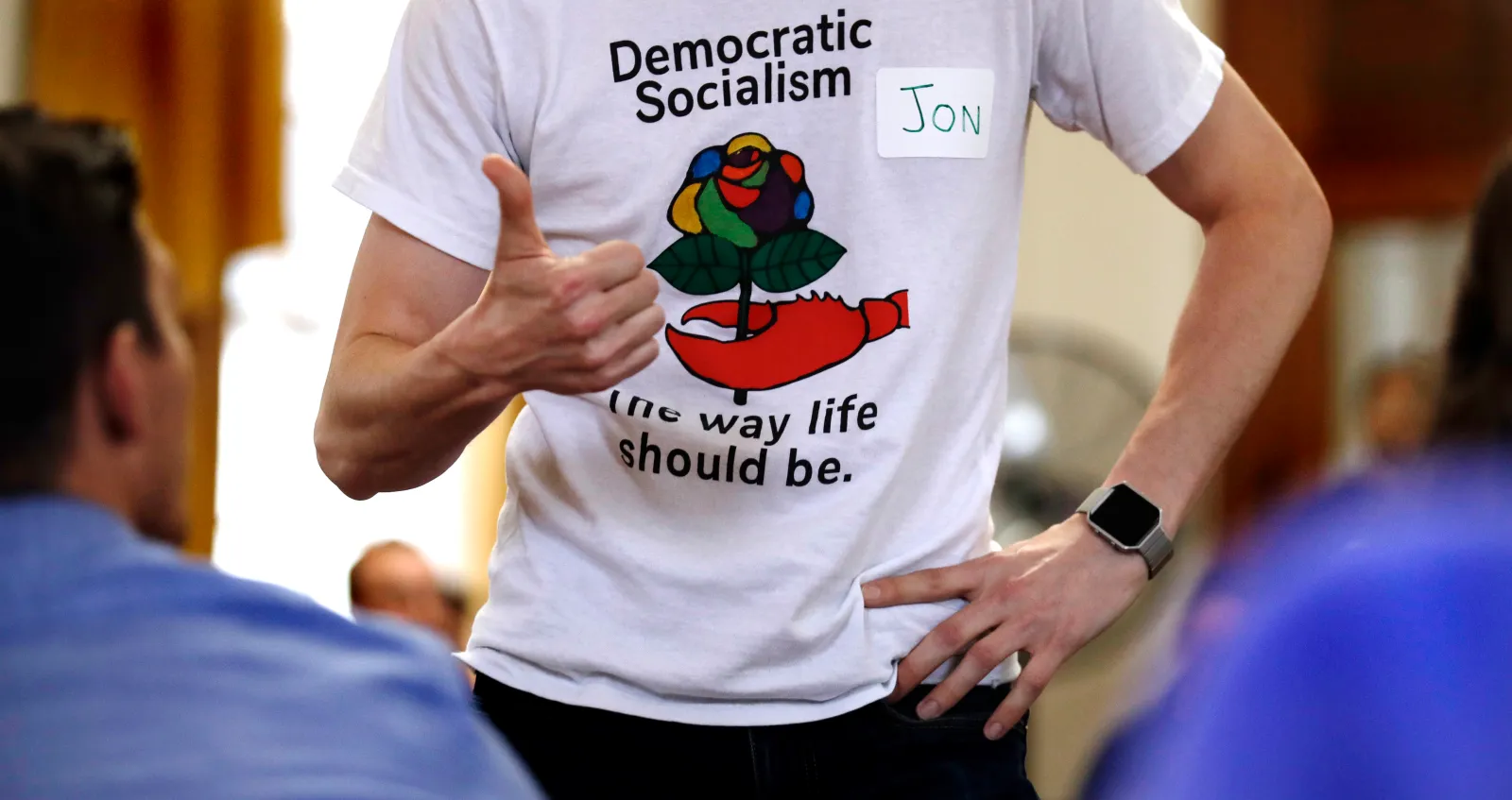 A man wears a T-shirt promoting democratic socialism during a gathering of the Southern Maine Democratic Socialists of America at City Hall in Portland, Maine, on July 16, 2018. (AP Photo/Charles Krupa)