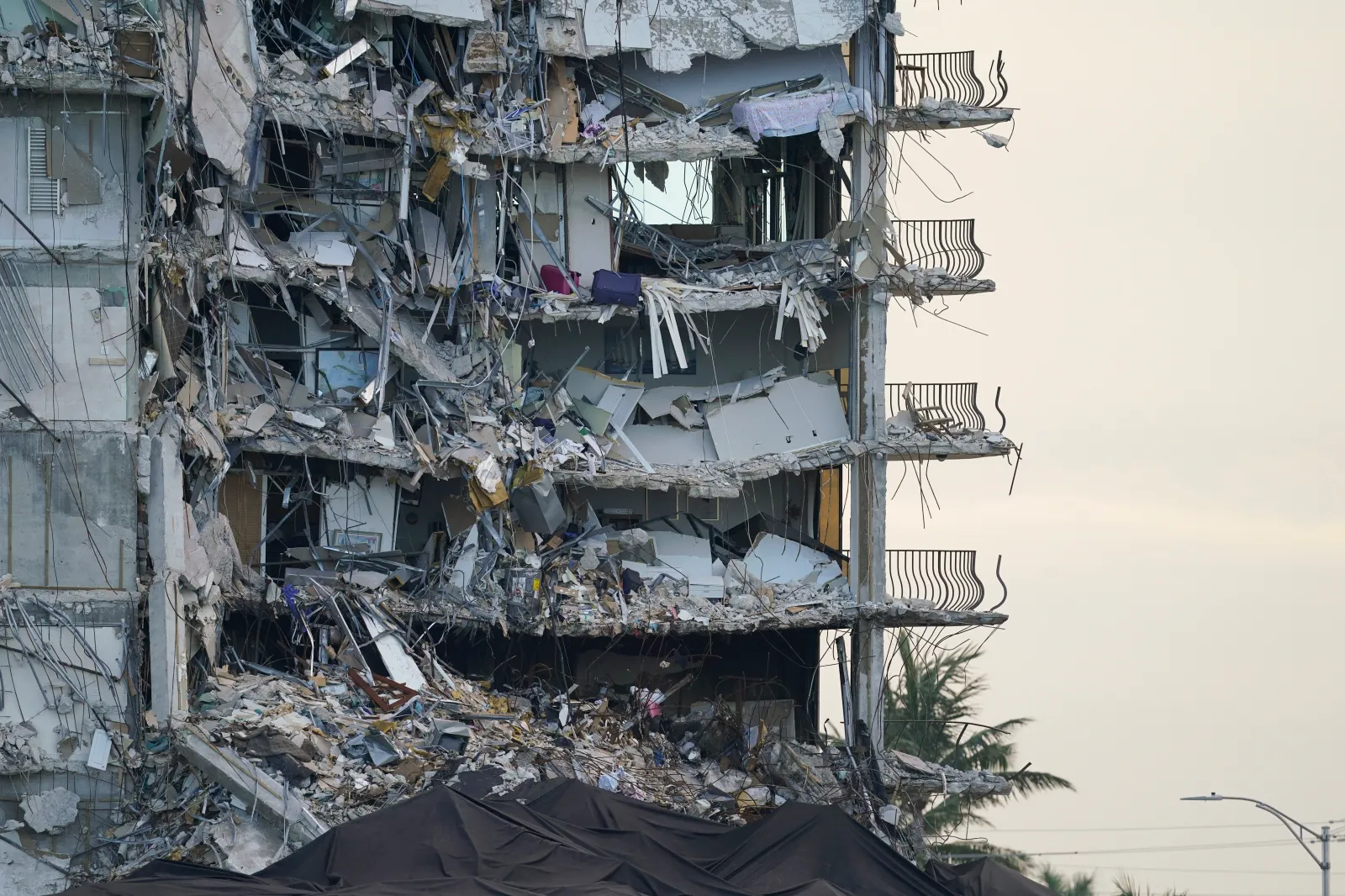 A giant tarp, bottom, covers a section of rubble at the Champlain Towers South condo building on July 4, 2021, in Surfside, Florida. (AP Photo/Lynne Sladky, File)