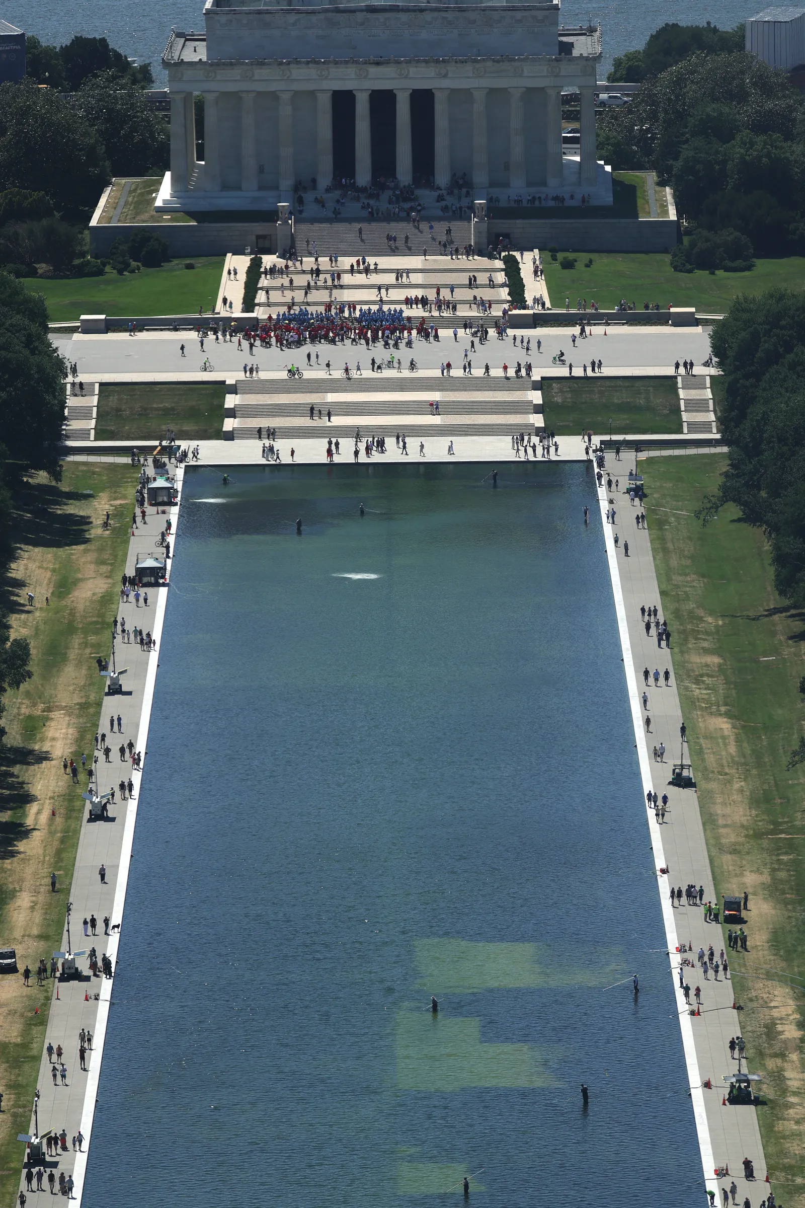 Workers clean the Lincoln Memorial Reflecting Pool as algae has bloomed in the pool after the $14 million renovation on June 20 in Washington, D.C. Credit: mpi34/MediaPunch /IPX