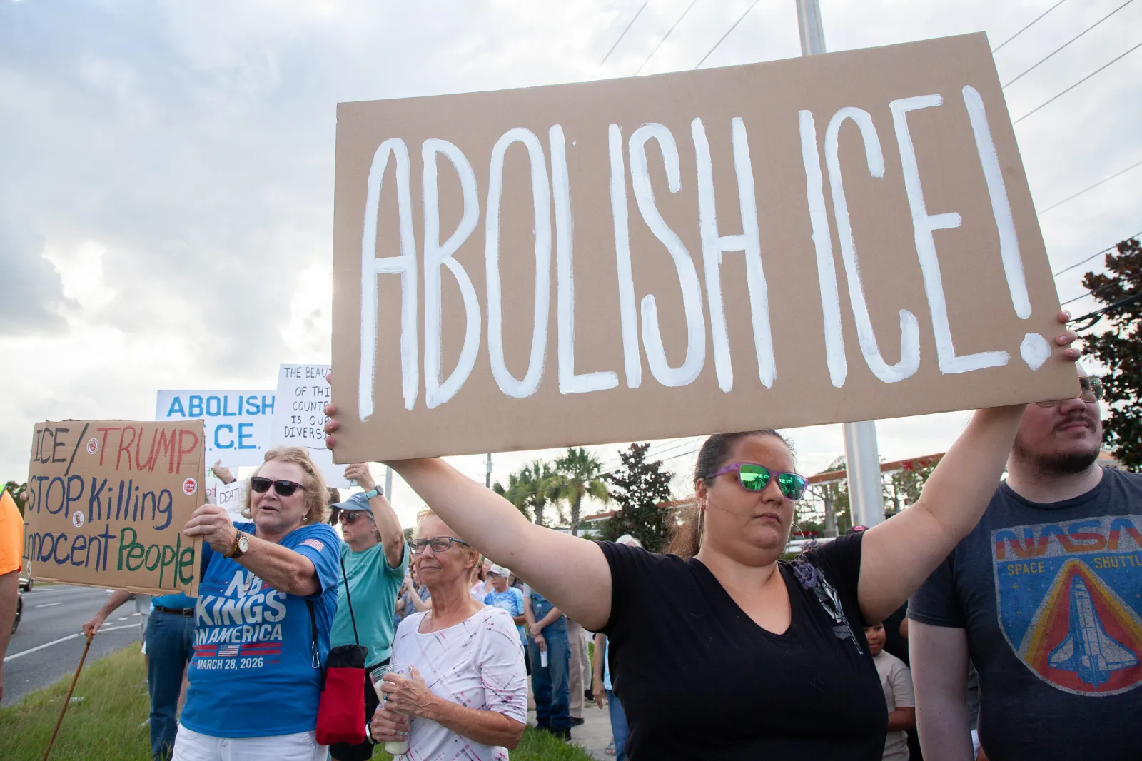 Protesters holding signs and candles line the roadway during a vigil for a Mexican man who was struck and killed by a tractor trailer while running from an encounter with Immigration and Customs Enforcements officers the day before on July 15 in St. Augustine, Florida. (AP Photo/Kelly Jordan)