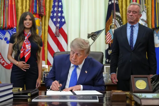 President Donald Trump signs an executive order about vaccines as Jayme Franklin, left, and Health and Human Services Secretary Robert F. Kennedy Jr. watch in the Oval Office of the White House in Washington, D.C., on August 10, 2026.