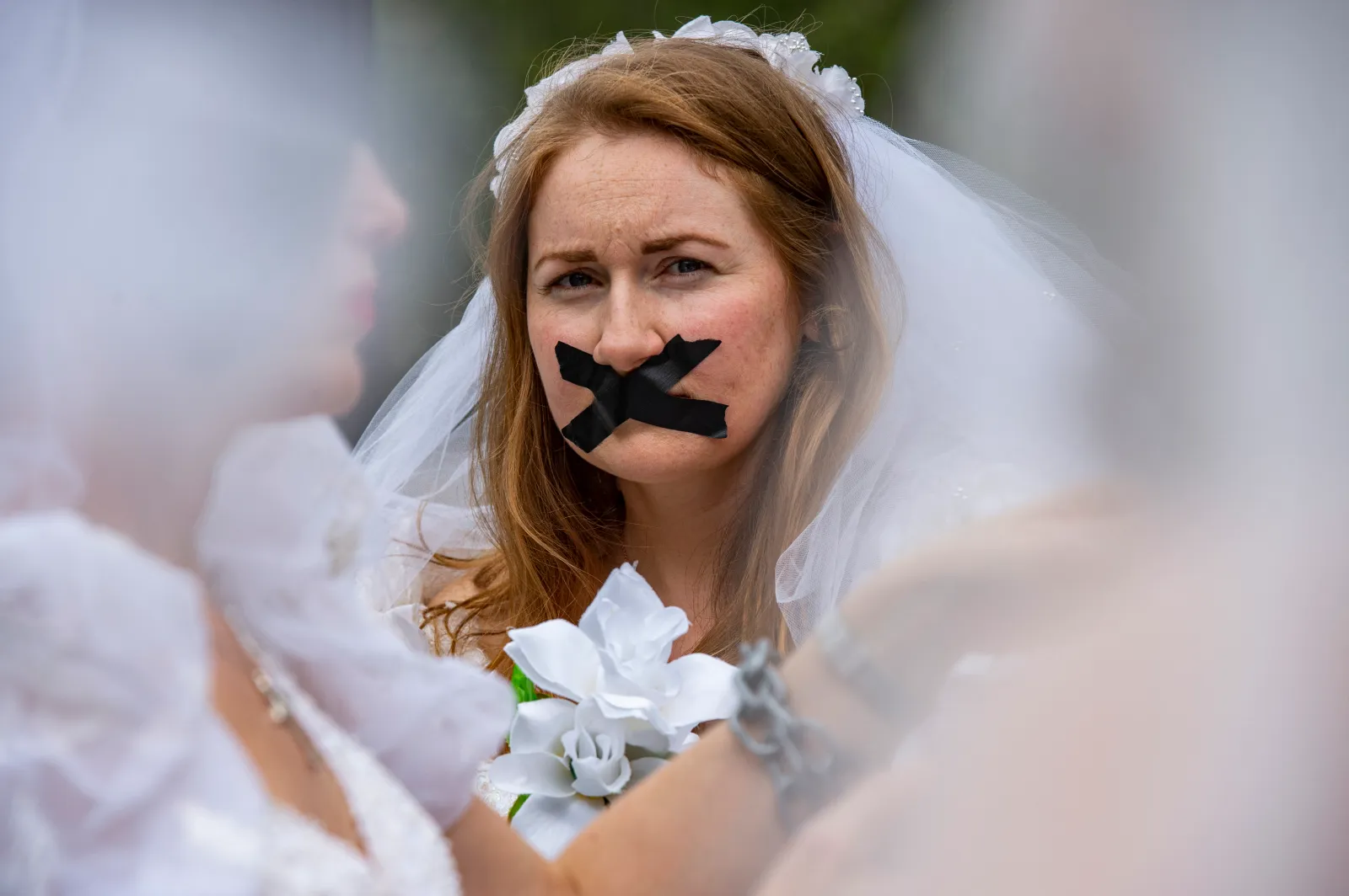 Advocates and child marriage survivors from the group "Unchained at Last" put on wedding gowns, veils, chains and tape over their mouths as they gather on Boston Common before marching to the State House to call for an end to child marriages in Boston on September 22, 2021.