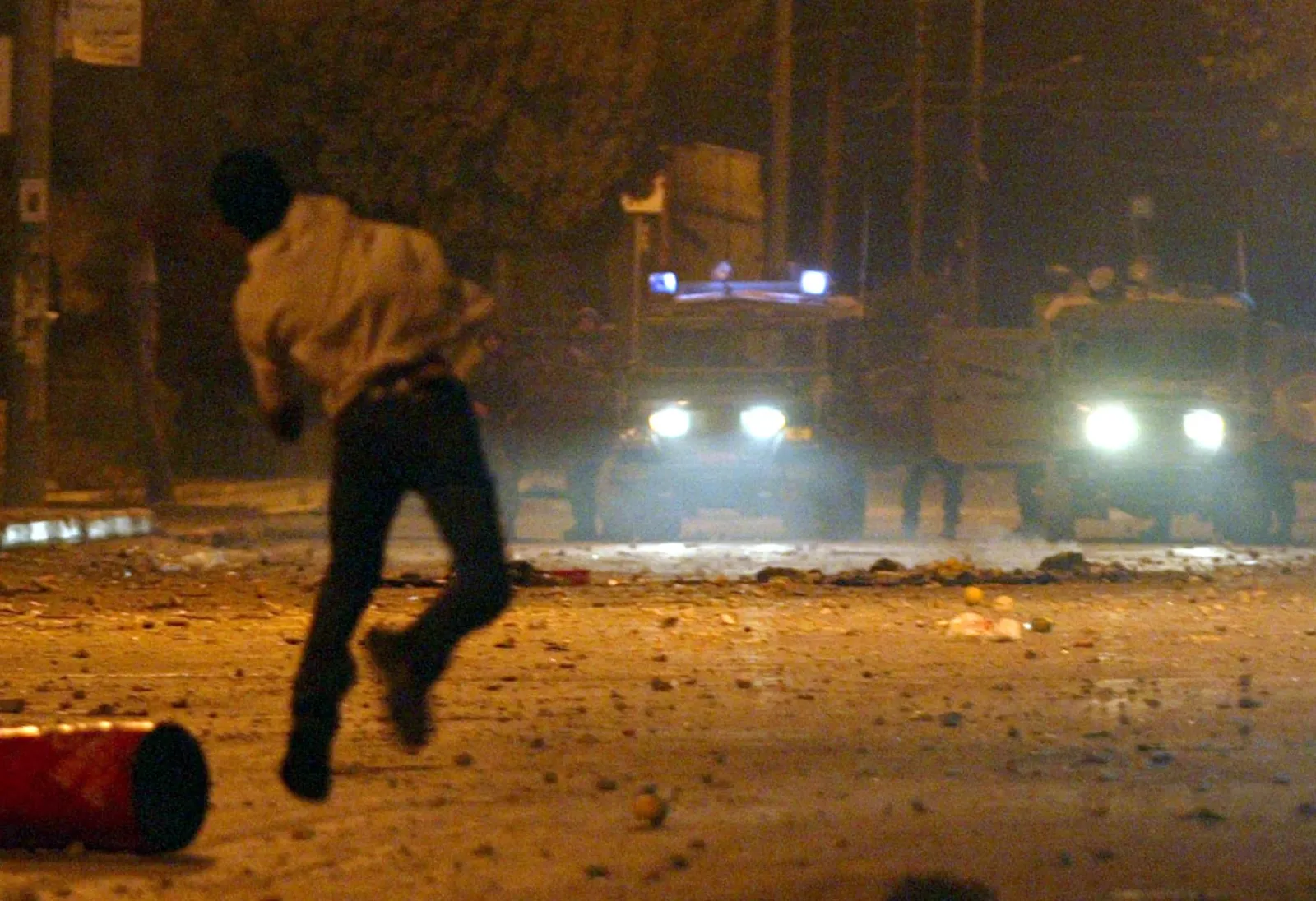 A Palestinian youth throws stones at Israeli soldiers during demonstrations in support of Palestinian leader Yasser Arafat on September 27, 2002, in Ramallah. (Photo by JAMAL ARURI/AFP via Getty Images)