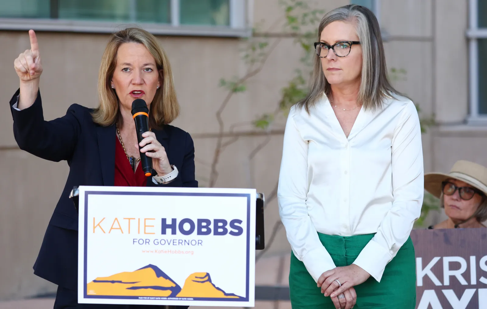 Katie Hobbs, right, looks on as Kris Mayes speaks at a news conference on October 7, 2022, in Tucson, Arizona. (Photo by Mario Tama/Getty Images)
