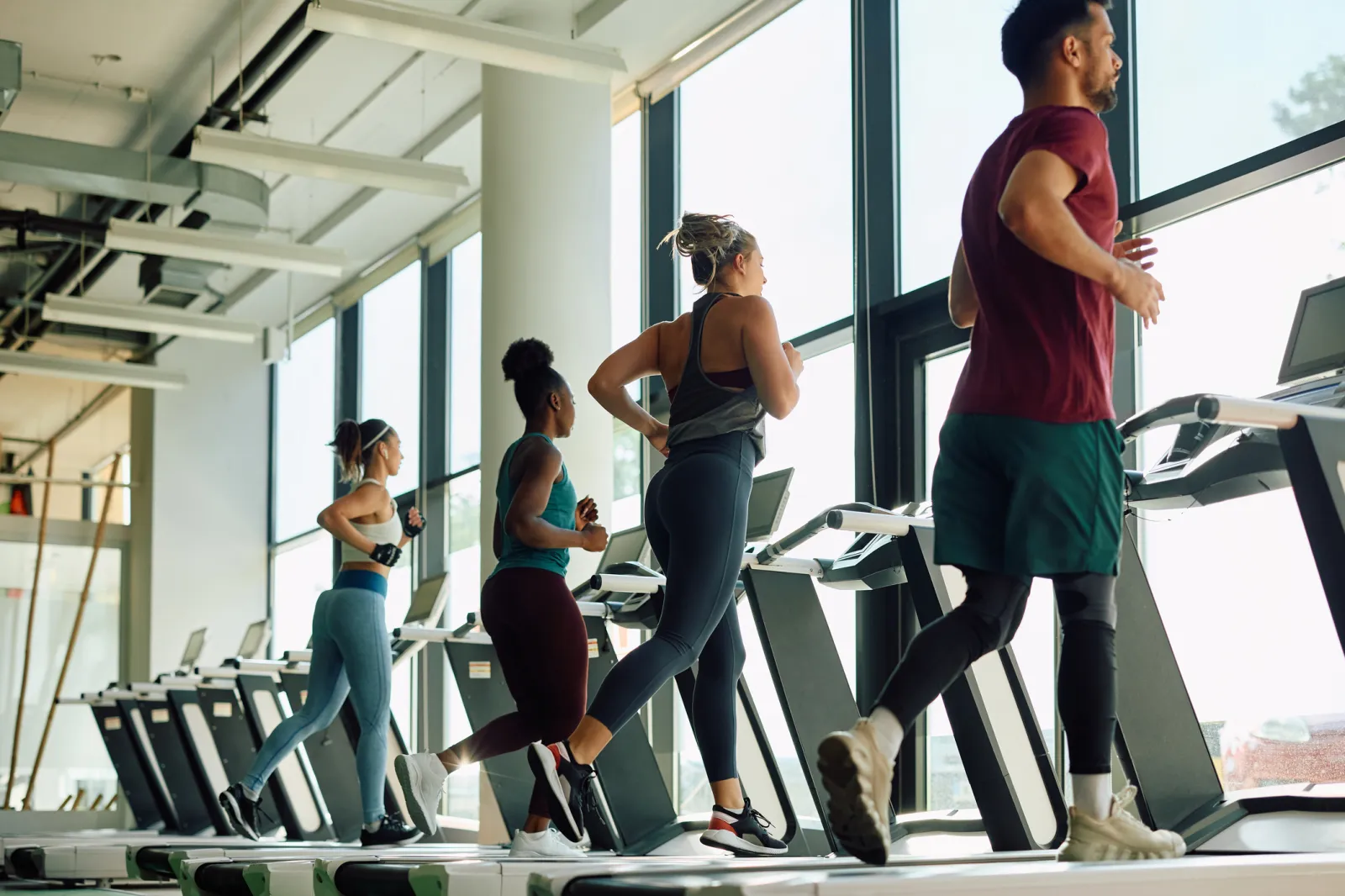 A stock image of young athletes running on treadmill while having sports training in a gym.