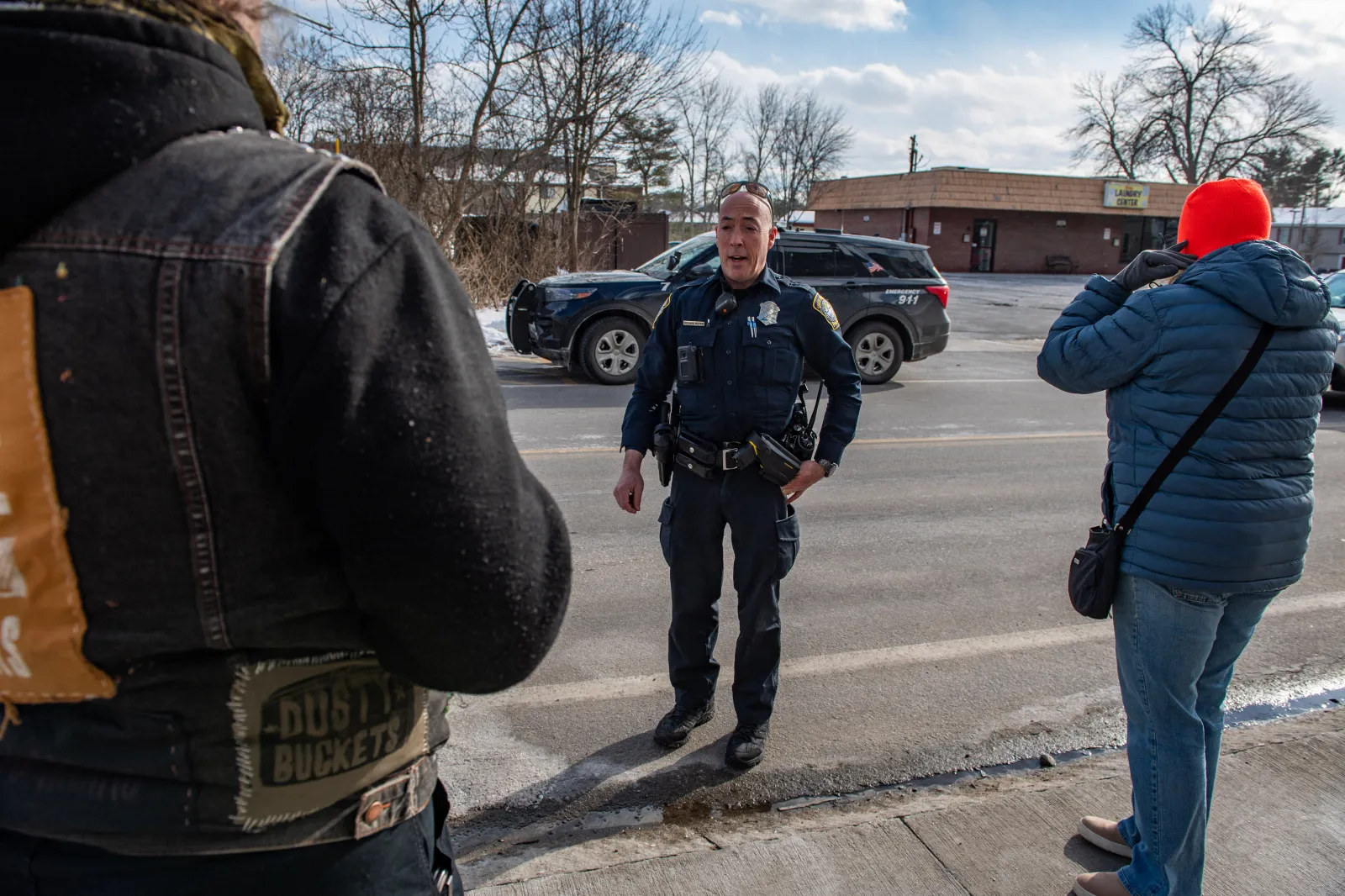 A local police officer tells a member of the concerned public not to trespass on private property after Immigration and Customs Enforcement (ICE) was allegedly spotted there in South Portland, Maine, on January 23, 2026. (Photo by Joseph Prezioso / AFP via Getty Images)
