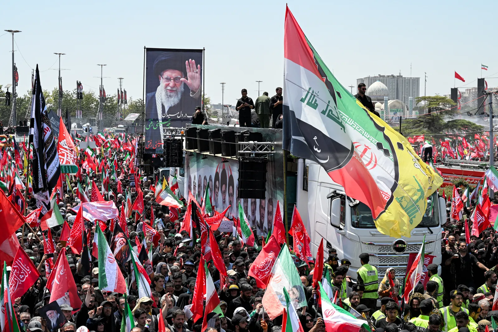 Mourners with the flags of Iran, Iraq, Hezbollah and other Shiite Muslim banners gather during a funeral procession for Iran's slain Supreme Leader Ayatollah Ali Khamenei at Azadi Square in Tehran on July 6, 2026.